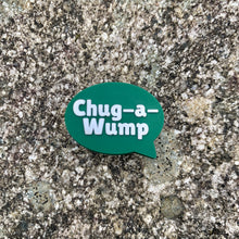 Load image into Gallery viewer, 1 inch tall, rubber Croc charm of a dark green speech bubble that says &quot;Chug-a-Wump&quot; sitting on grey, speckled stone.
