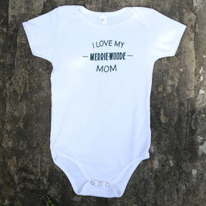 White baby onesie that says "I love my Merrie-Woode Mom" across the chest. 