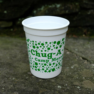 Small white plastic cup with green polka dots and the phrase "chug-a-wump!"